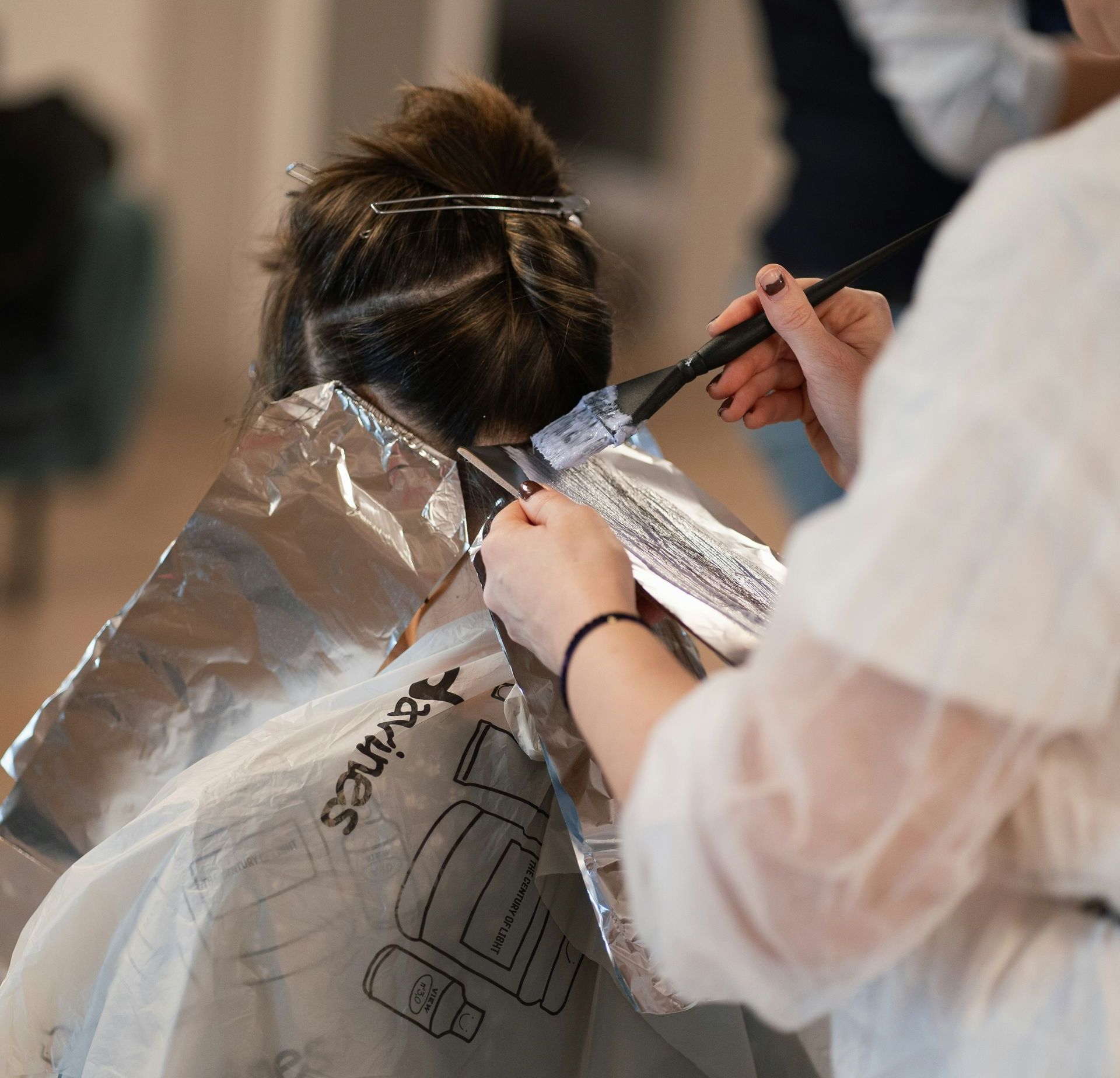 a woman is getting her hair cut by a hair stylist